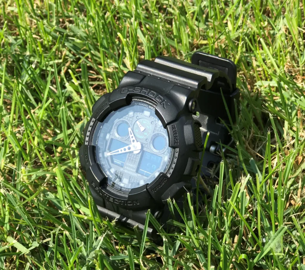 Black Casio G-Shock analog-digital watch photographed on grass